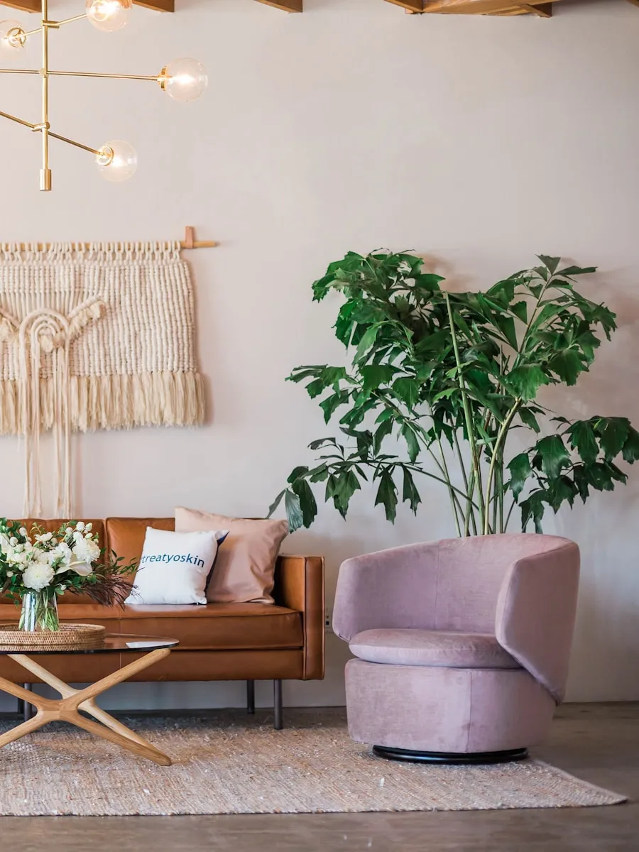 Salon bohème avec macramé, canapé caramel, tapis superposés et plantes