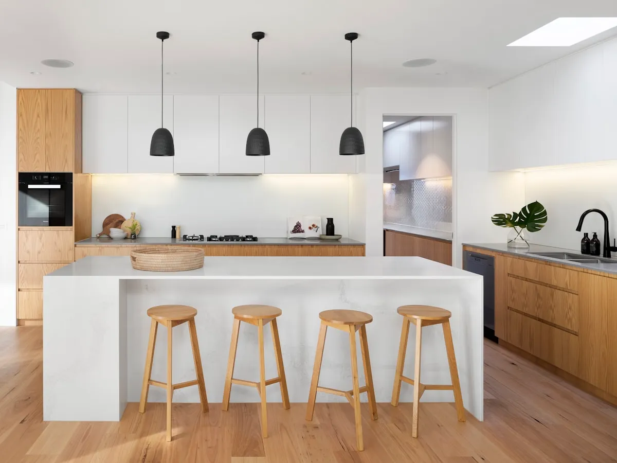 Cuisine claire avec îlot et tabourets bois