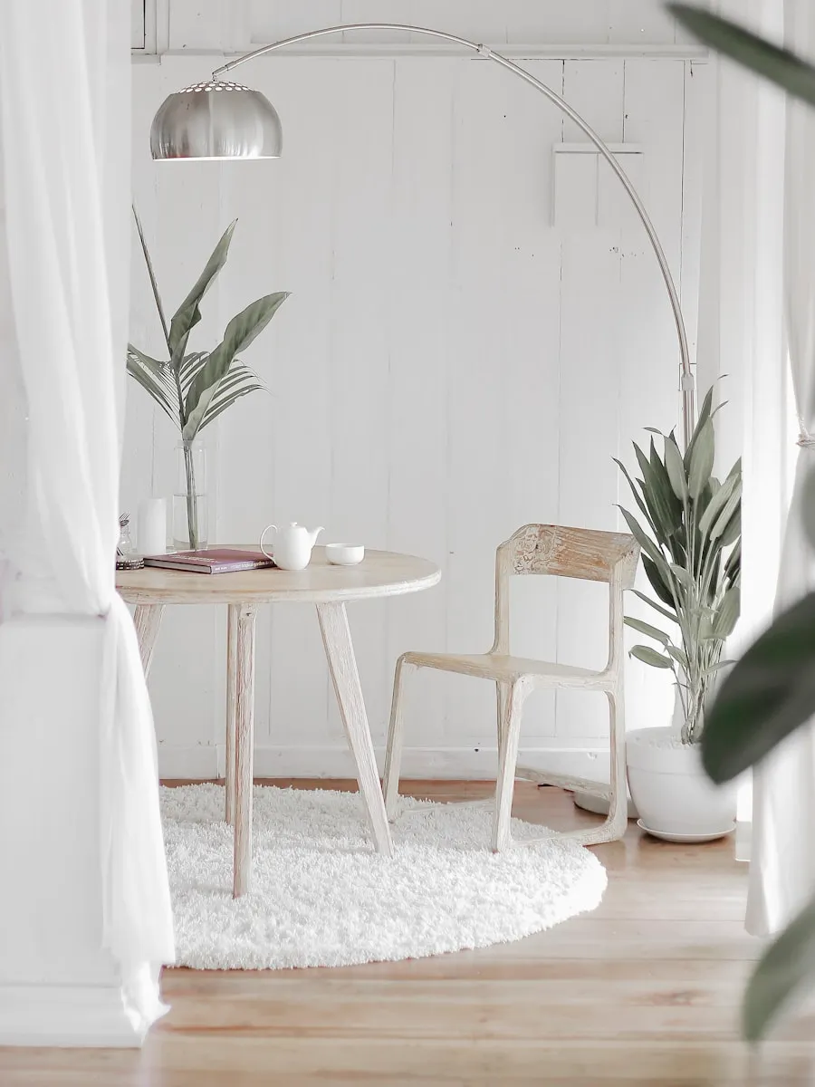 Pièce minimaliste, murs blancs, mobilier réduit et ombres portées nettes