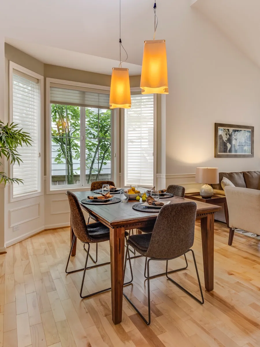 Salle à manger avec table en bois, chaises et suspensions en verre ambré