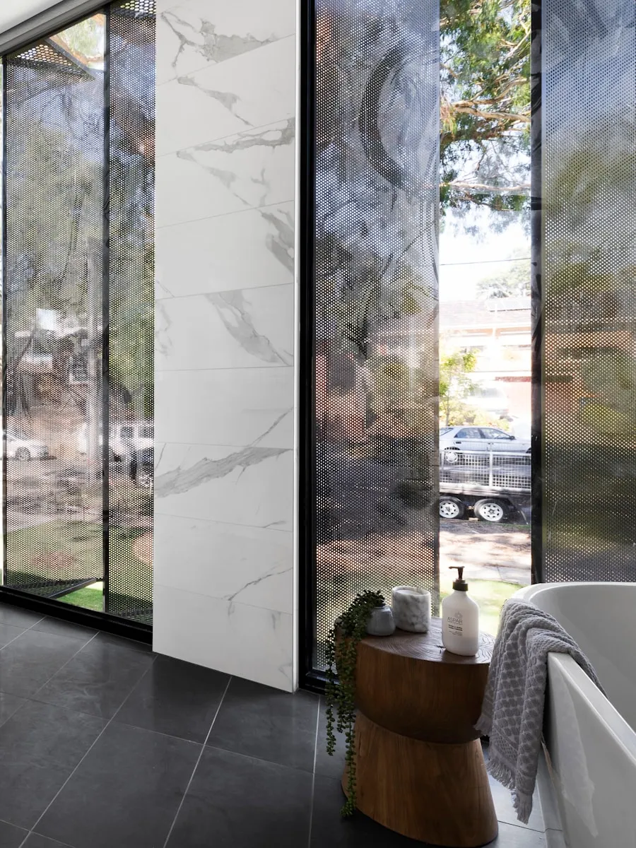 Salle de bain avec vasque en marbre, carrelage sombre et menuiserie noire