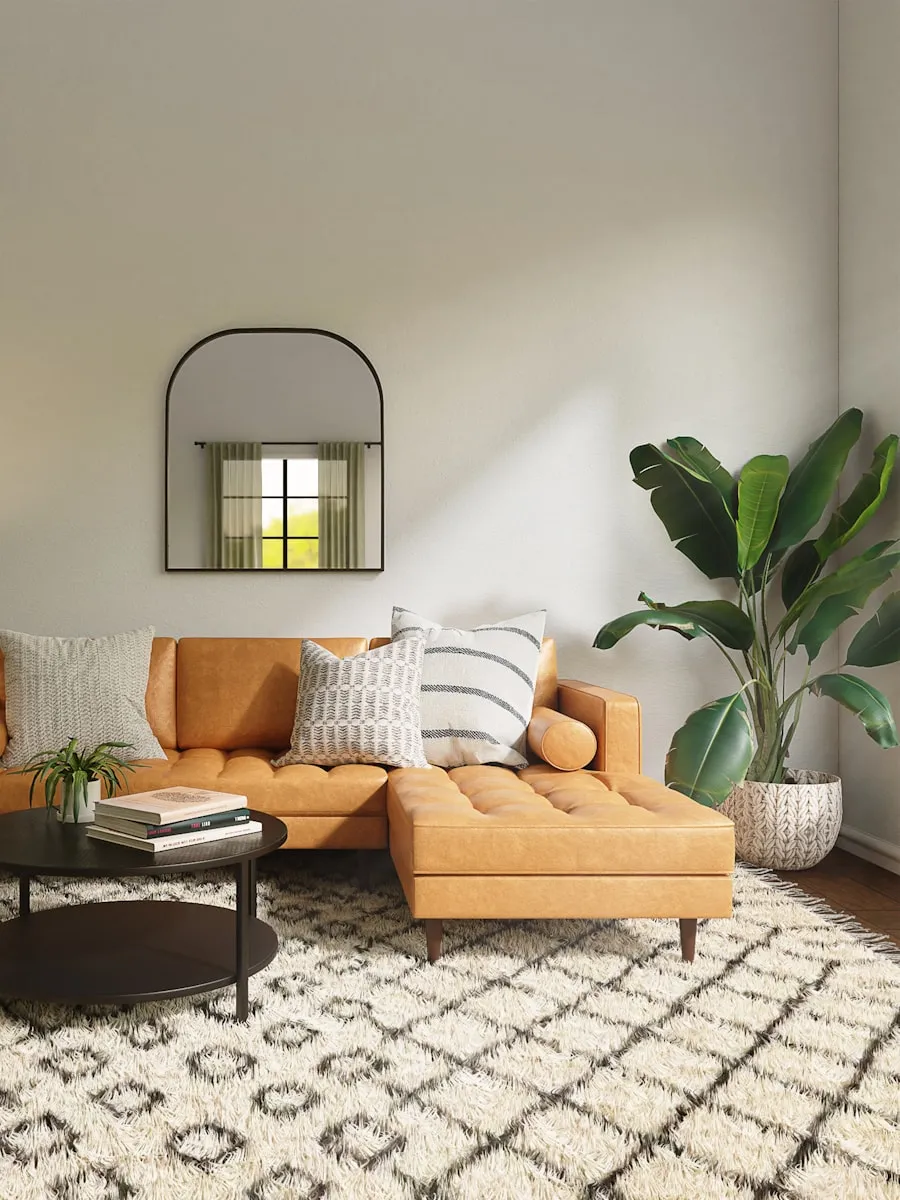 Salon avec canapé en cuir caramel, tapis à motifs et plantes